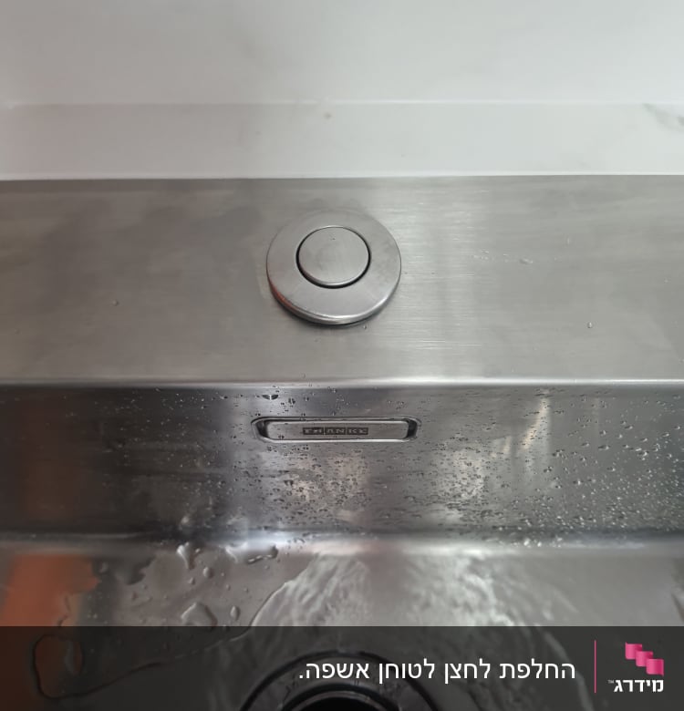 כיור נירוסטה עם כפתור ומים זורמים